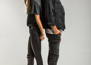 Man and woman in studio wearing denim standing back to back