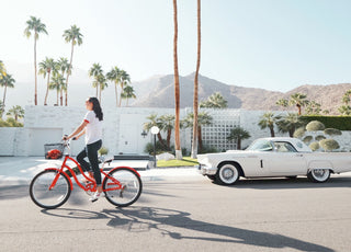 Woman riding red bike in down California street