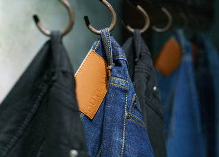 outland denim jeans hanging on hooks